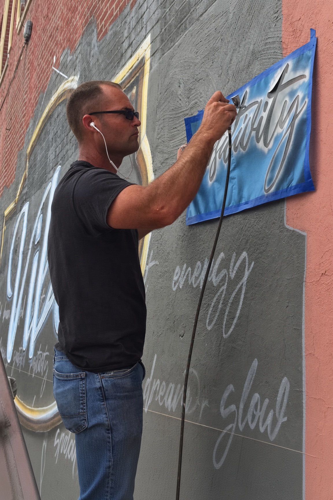 Airbrushing lettering on a brick mural